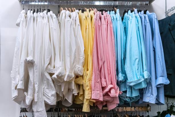 männer langarm-leinenhemden zum verkauf in einem bekleidungsgeschäft - shopping retail shirt coat hook stock-fotos und bilder