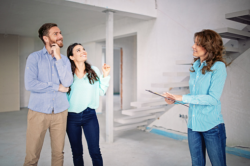 Real estate agent is showing new apartment to a young couple