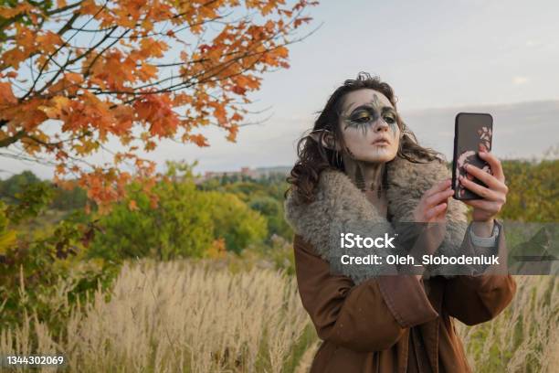 Woman In Halloween Elf Costume Taking Selfie In The Forest Stock Photo - Download Image Now