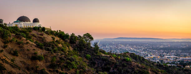 Griffith Observatory with LA skyline in the background at sunset Griffith Observatory with LA skyline in the background at sunset griffith park observatory stock pictures, royalty-free photos & images