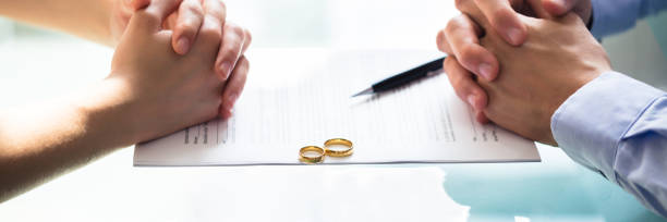 istock Couple's Hand On Divorce Paper 1344305232