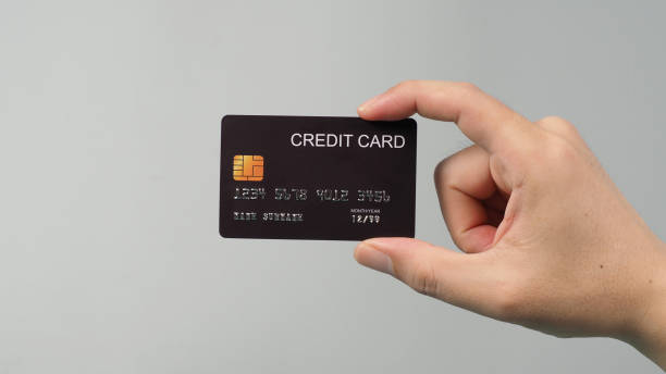 istock Hand is holding black credit card isolated on grey background. 1344306081