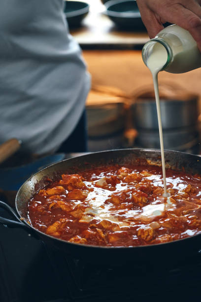 istock Preparing Indian Chicken Curry with Naan Bread and Poppadum 1344307281