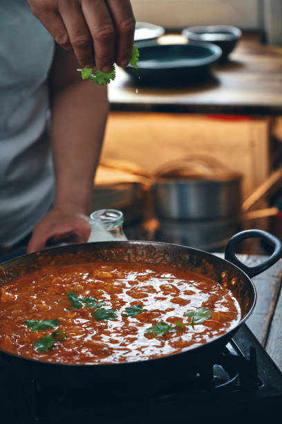 istock Preparing Indian Chicken Curry with Naan Bread and Poppadum 1344307289