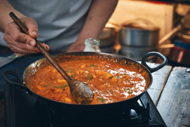 istock Preparing Indian Chicken Curry with Naan Bread and Poppadum 1344307304
