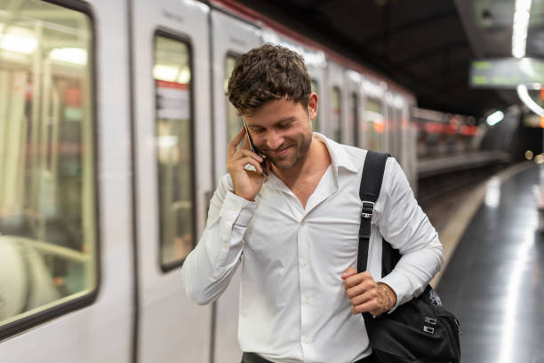 istock Glad businessman having smartphone conversation on station 1344309531