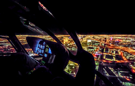 cockpit view and defocused aerial view of Las Vegas at night