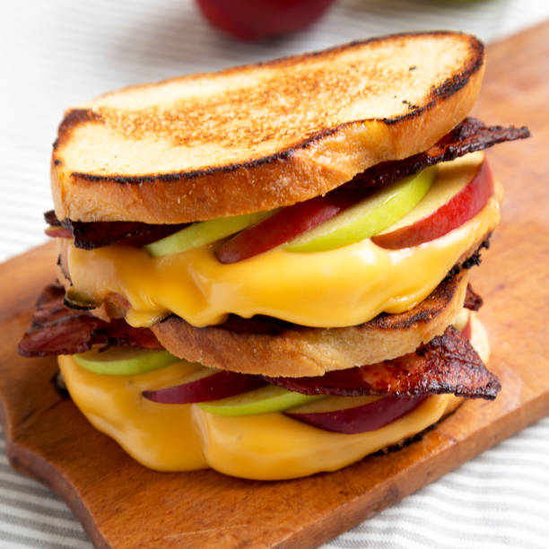 istock Homemade Bacon Apple Grilled Cheese on a rustic wooden board, low angle view. Close-up. 1344309710