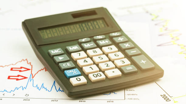 istock vintage calculator with numbers on screen stands on graphs 1344310829