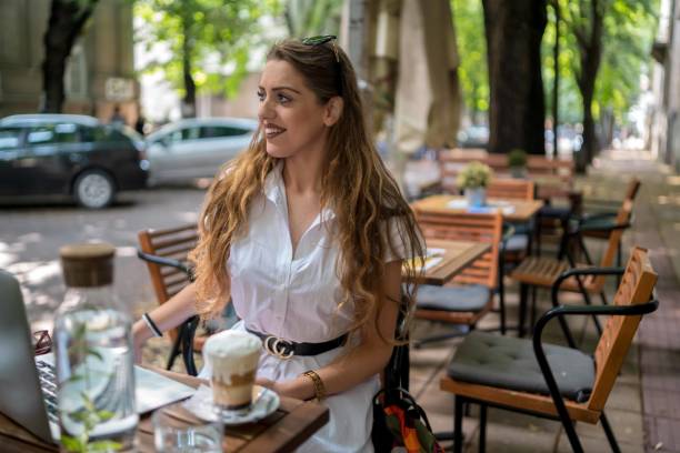 istock Businesswoman using laptop while enjoying work at cafe table with cup of coffee 1344311617