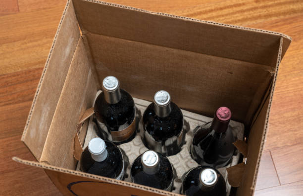 Open box or case of six bottles of wine after home delivery Open box of a half-dozen bottles of wine for home delivery sitting on wooden floor wine shipping stock pictures, royalty-free photos & images