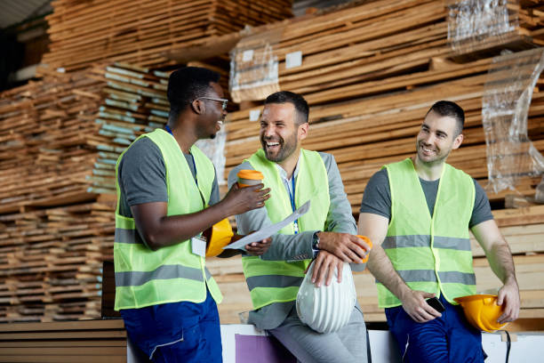 Happy manager and male workers having fun on coffee break at distribution warehouse.