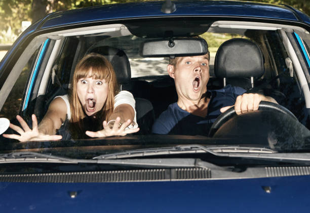 istock Young couple react to danger with shock and horror as they drive in a car 1344313576