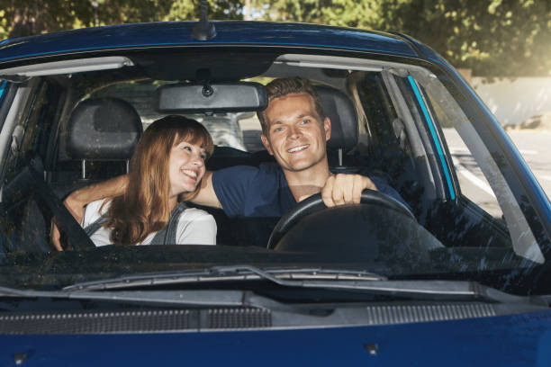 istock Loving young couple driving in a car 1344313588