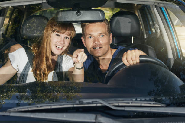 istock Good-looking young couple driving in a car 1344313603
