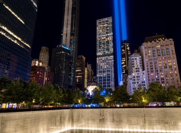 9/11 Tribute in Light. Lower Manhattan illuminated at night. Memorial South Pool. View from Ground Zero, Manhattan, USA. New York, USA - September 11, 2021:    Tribute in Light. Lower Manhattan illuminated at night. Memorial South Pool. View from Ground Zero, Manhattan. to the struggle against world terrorism statue photos stock pictures, royalty-free photos & images