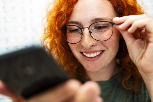 istock Redhead young woman looking at smart phone 1344315643