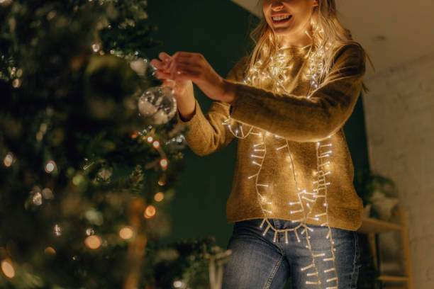 istock Young woman decorating a Christmas tree 1344320118