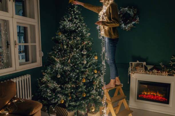 istock Young woman decorating a Christmas tree 1344320216