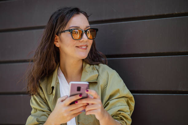 istock Young modern woman using mobile phone on the go 1344323475