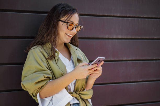 istock Young modern woman using mobile phone on the go 1344323525