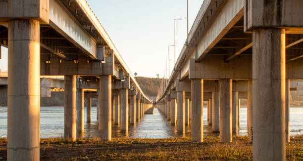 istock Highway bridge crossing a river during the sunset with graffitis on their pillars taken from the front side 1344324097