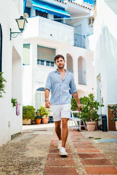 istock Man walking on sunlit town street 1344327432