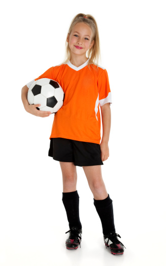 Nine year old girl holding soccer ball isolated on white.