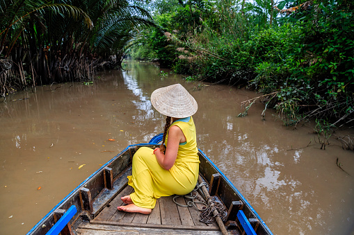 Female tourist on boat in Mekong River Delta, Vietnam.