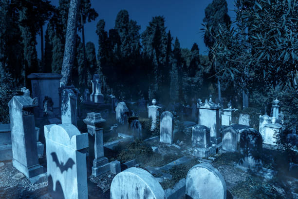 istock Cemetery in forest on Halloween, scary graveyard with mist and bats 1344338937