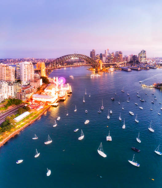 Sunset aerial view over Lavender bay on Sydney harbour towards city waterfront landmarks around the Harbour bridge.