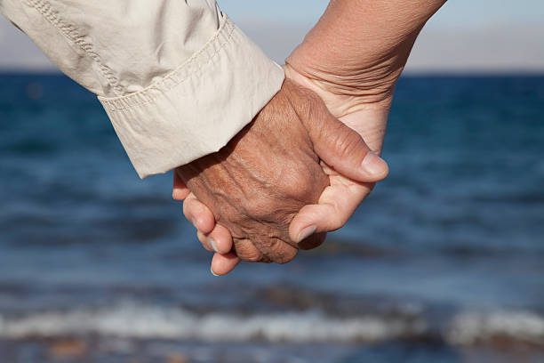 istock Senior couple holding hands on the beach 134435012