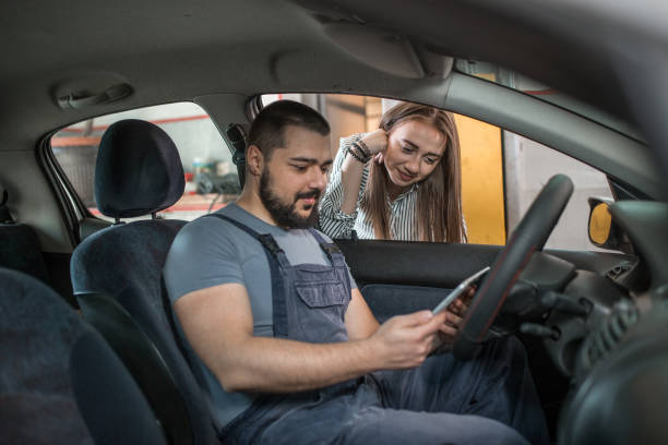 istock Young female driver and car mechanic searching for solution for car breakdown on tablet 1344353004