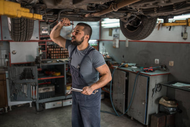 istock Car mechanic using tool to change the wheel on a car in garage 1344353032