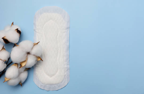 istock Cotton plant flower and sanitary pad on light blue background. 1344356834