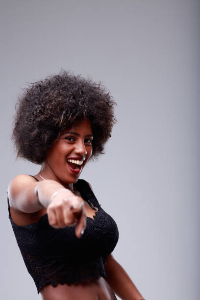 istock Laughing vivacious young woman pointing to the camera 1344357706