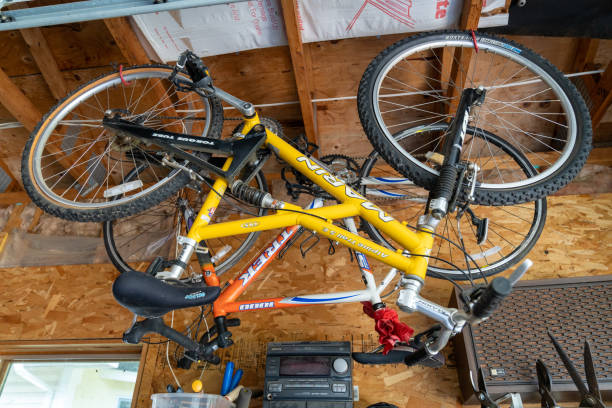 Two bikes hanging from the ceiling in a garage, for winter storage stock photo
