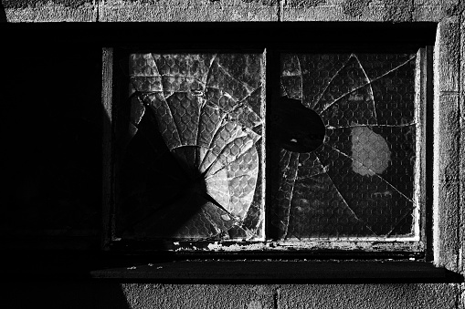 City, black and white. Broken glass window