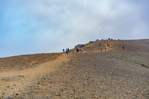 A big group of Tourist hiking to view point of volcano Fagradalsfjall.  In background is cloudy sky. Half months ago there was an big eruption.