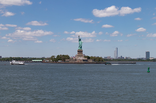 The Statue of Liberty on Liberty Island along the Hudson River with a beautiful blue sky in New York City