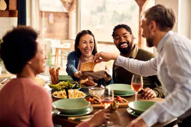 istock Happy multi-ethnic friends having fun while eating together at dining table. 1344366723