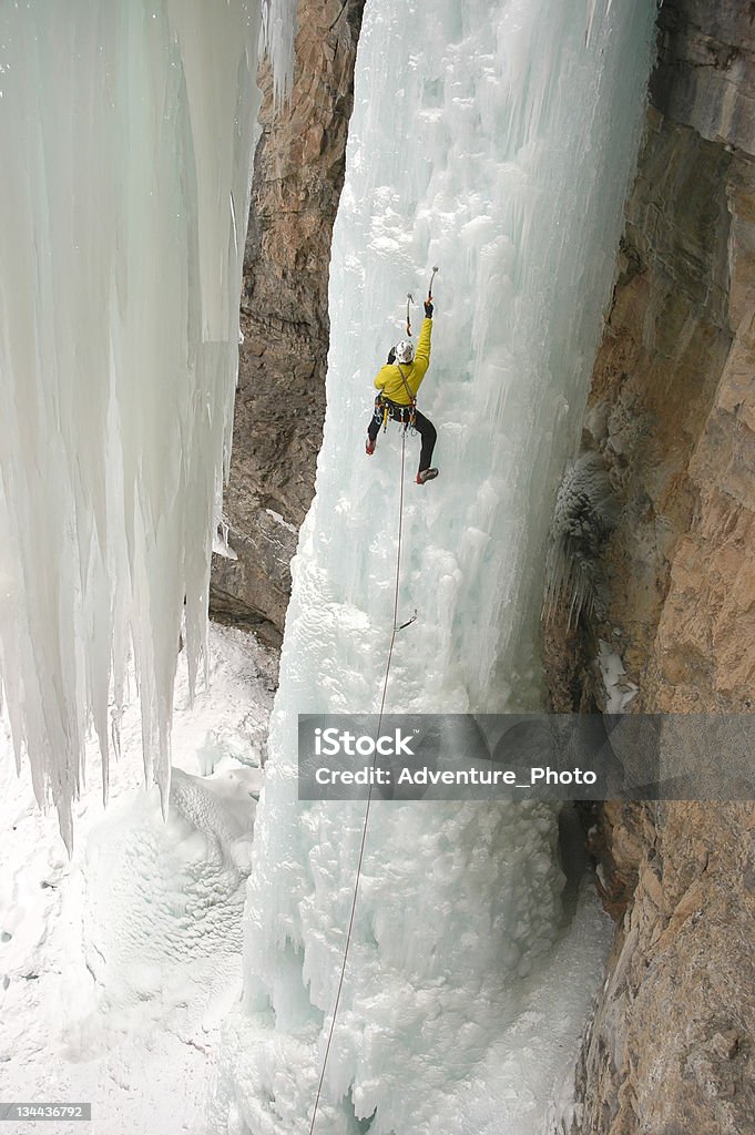 Ice Climber Extreme Adventurer on Steep Frozen Waterfall Achievement Stock Photo