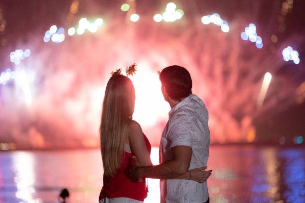 istock Young couple enjoy firework during celebration festival on the beach. 1344369193