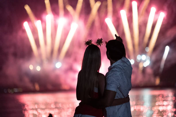 istock Young couple enjoy firework during celebration festival on the beach. 1344369194