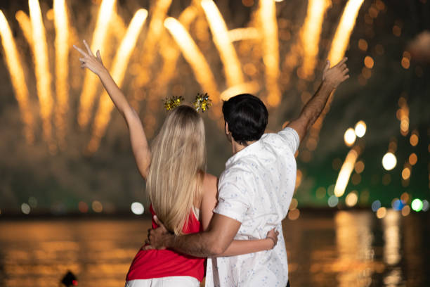 istock Young couple enjoy firework during celebration festival on the beach. 1344369197