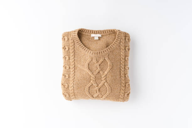 Beige folded sweater isolated on white background. Flat lay. Top view