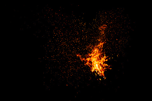 Blazing fire flame with a lot of sparks isolated on black background