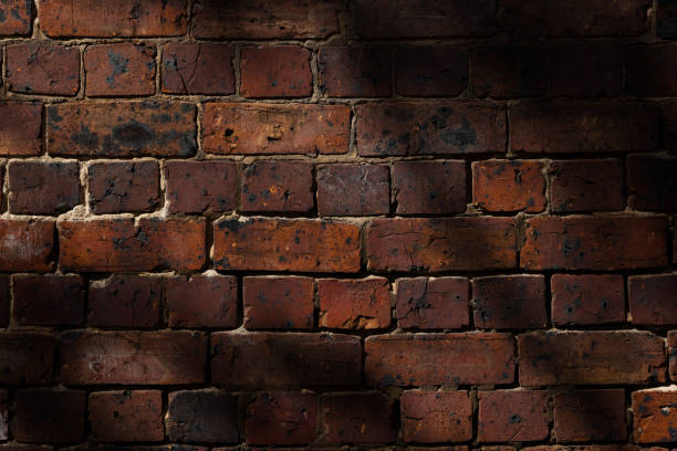 istock Part of an old brick wall with shadows 1344380563