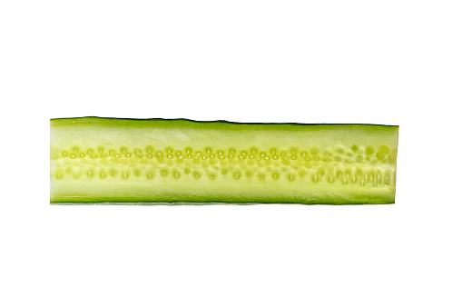 Extreme close-up macrophotography of sliced cucumber vegetable isolated on white background.