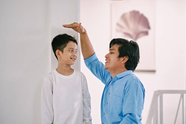 Father Measuring His Son Height